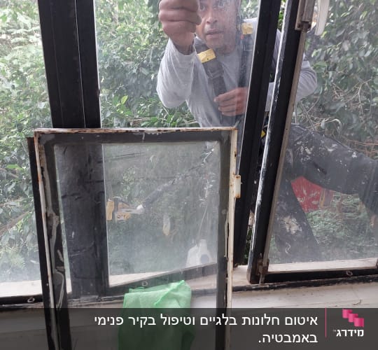 אדם עם קסדה מתקין חלון מבחוץ